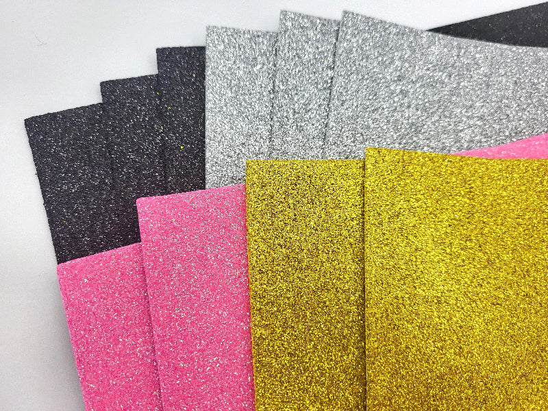 Glittery paper sheets in various colors on a white background