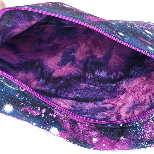 Close-up of a purple and pink galaxy-patterned bag with a zipper.