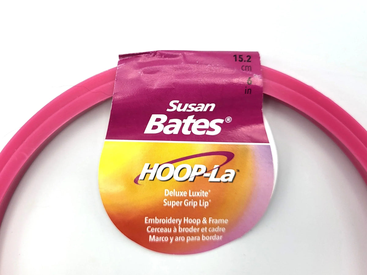 Pink embroidery hoop with Susan Bates HOOP-La packaging on a white background