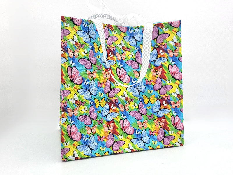 Colorful butterfly-patterned gift bag on a white background