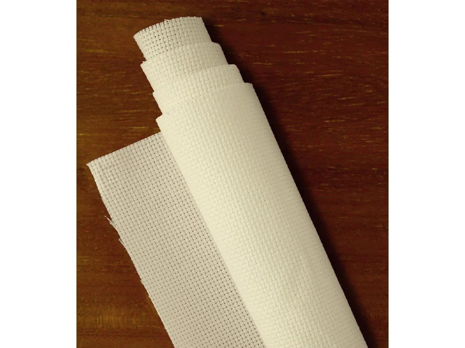 Roll of white mesh fabric on a wooden surface