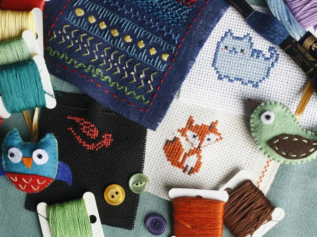 Cross-stitched fabric with animal designs and embroidery threads.