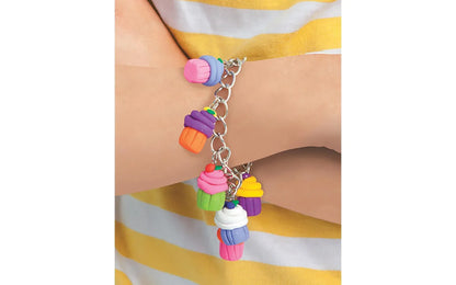 Colorful cupcake charm bracelet on a wrist with a striped background