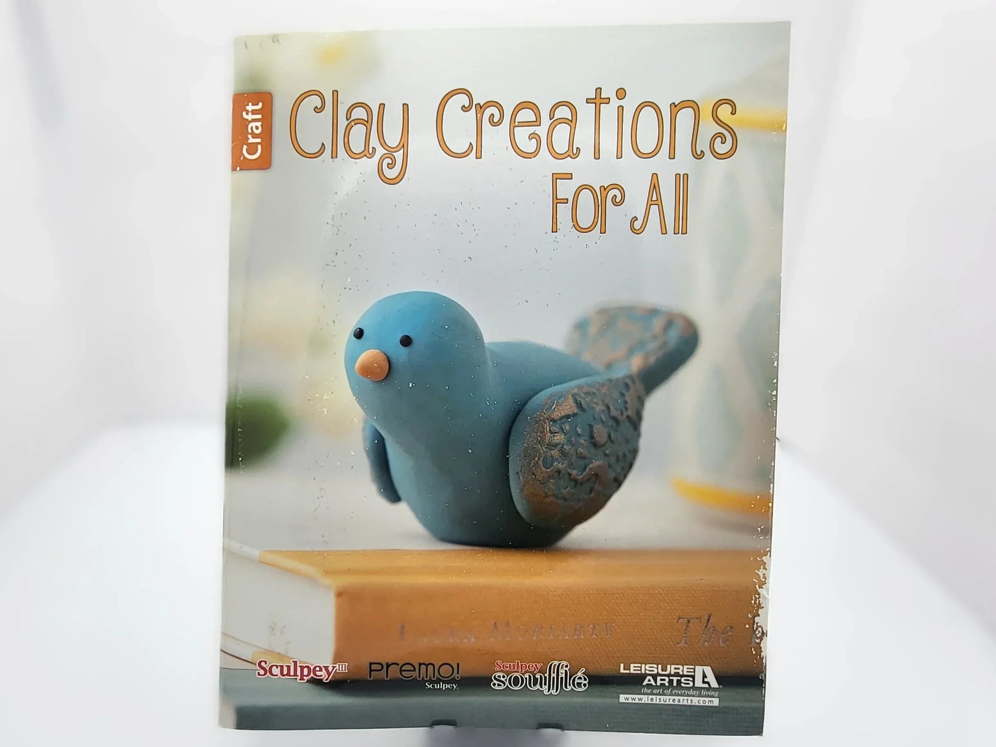 Book titled 'Clay Creations For All' with a clay bird sculpture on the cover.