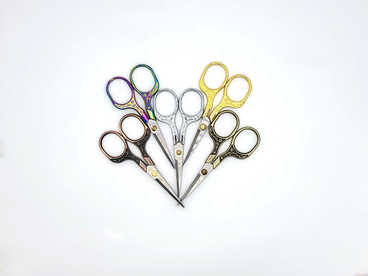 Set of five pairs of scissors with different handles on a white background
