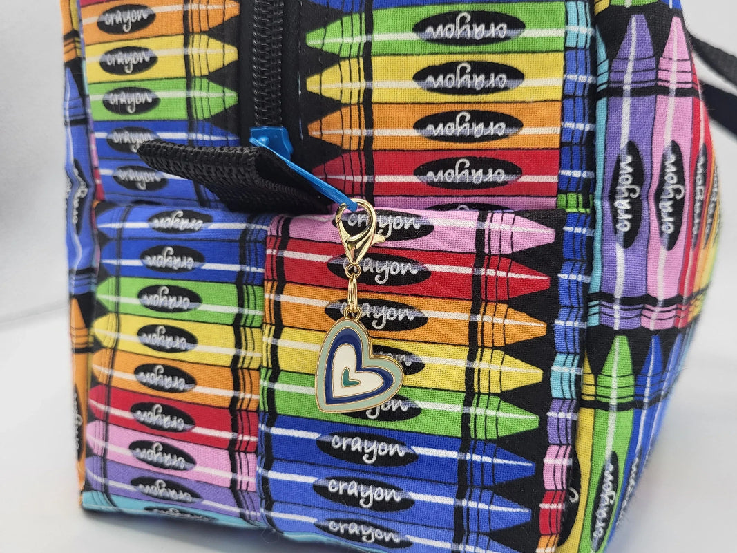 ide view of crayon print duffle bag showing 1" webbing tab and clip-on detail