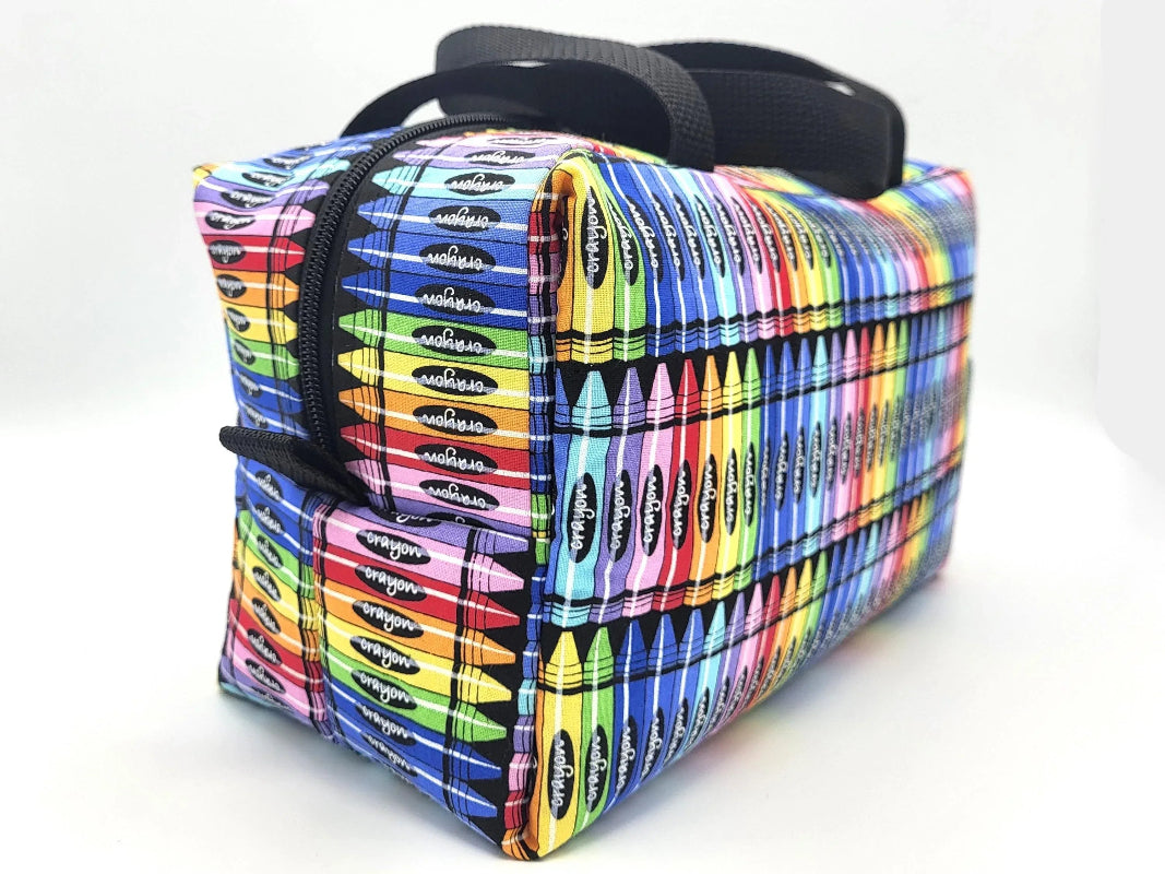 Second side view of crayon print duffle bag showing webbing handle and structure