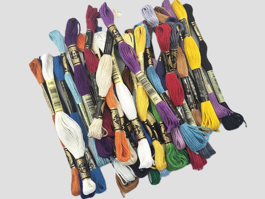 Assorted skeins of embroidery thread on a light gray background