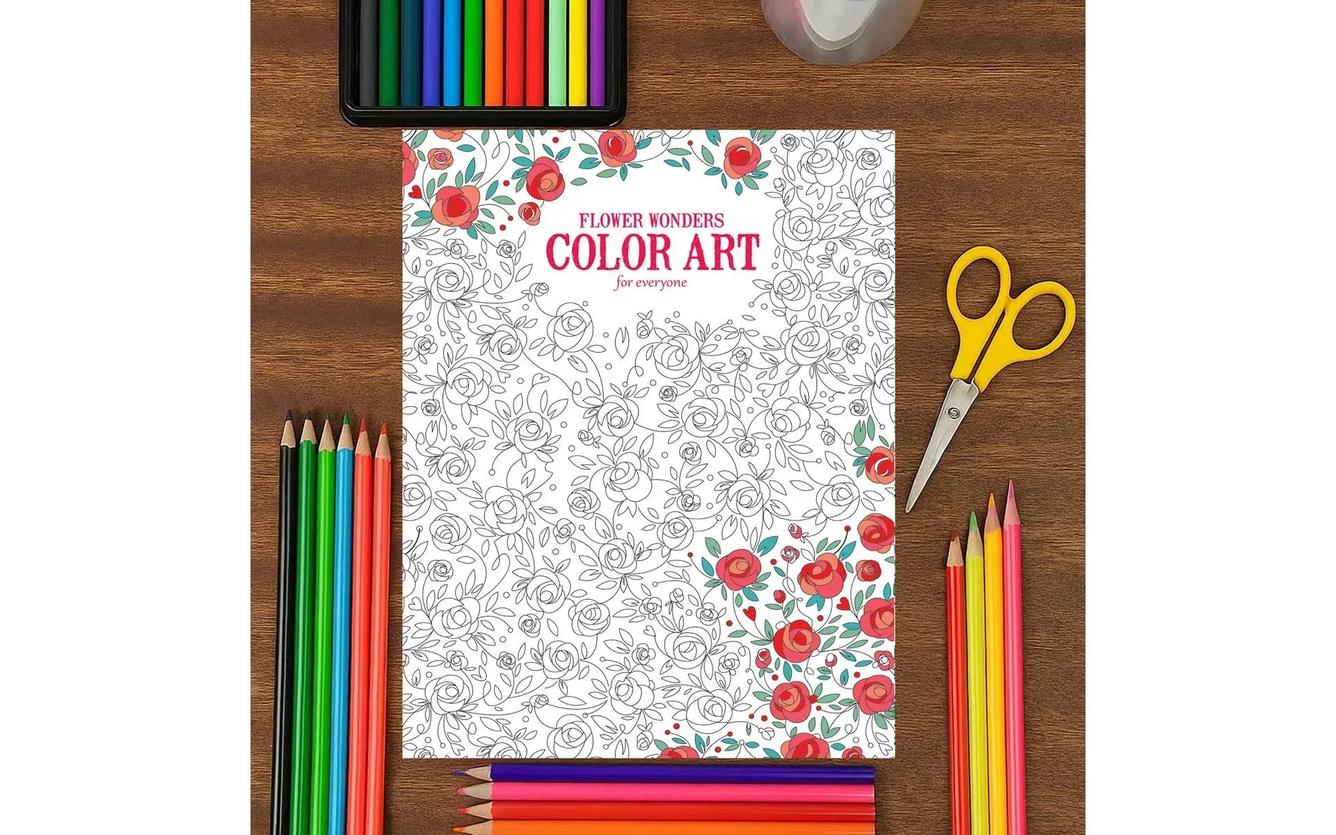 Coloring book with markers, scissors, and a glass on a wooden surface