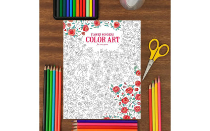 Coloring book with markers, scissors, and a glass on a wooden surface