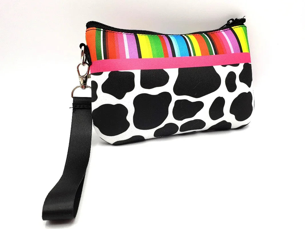 Multicolored striped pouch with a cow print design on a white background