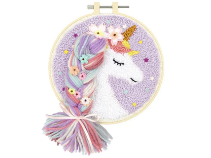 Embroidery hoop with a unicorn design and yarn tails on a white background