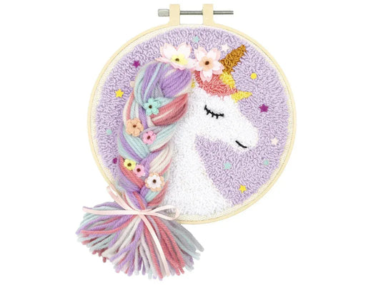 Embroidery hoop with a unicorn design and yarn tails on a white background