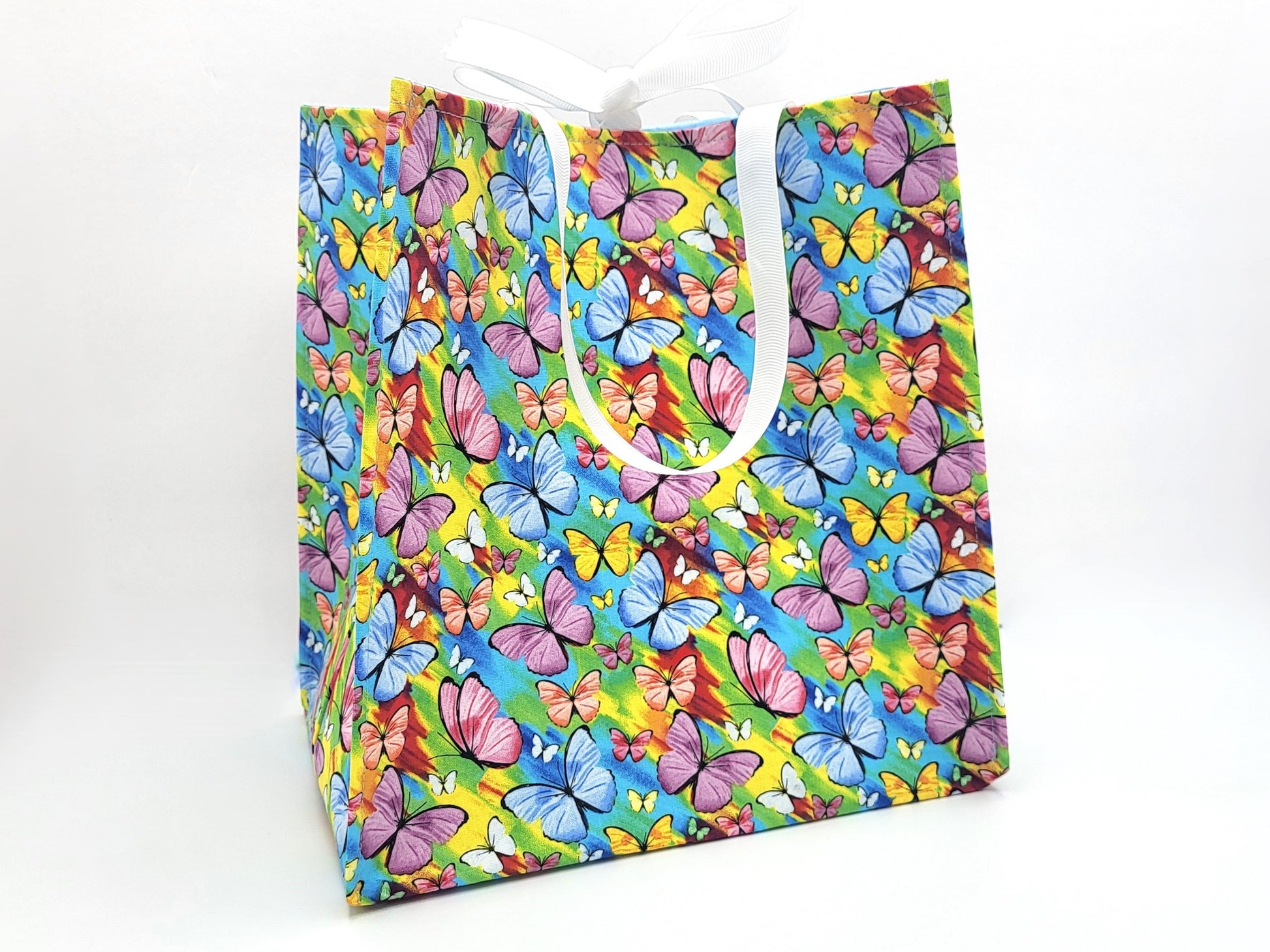 Colorful butterfly-patterned gift bag on a white background