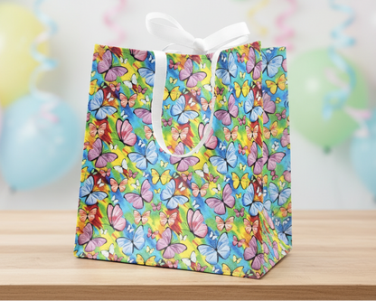 Colorful butterfly-patterned gift bag on a wooden surface with pastel balloons in the background