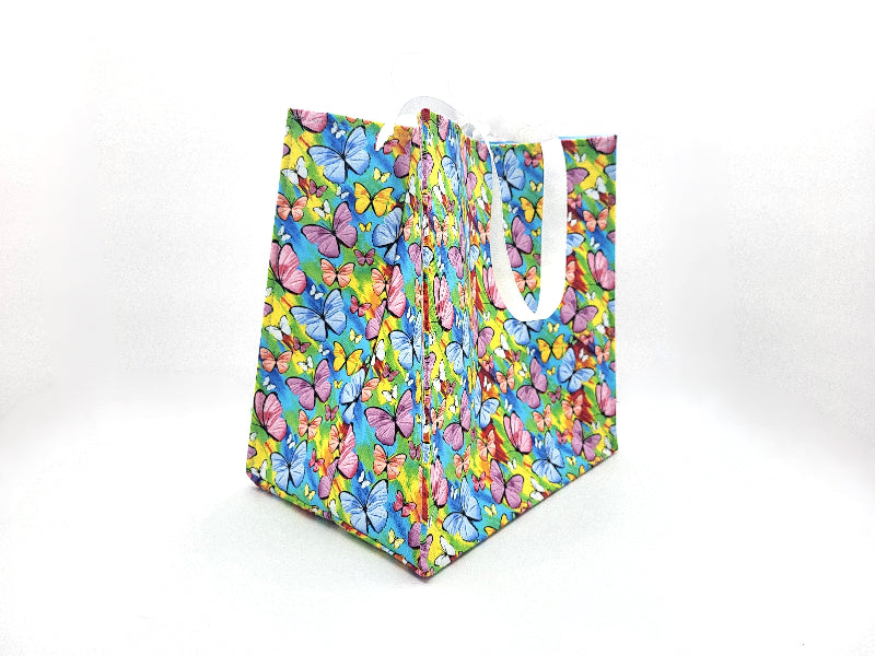Colorful butterfly-patterned gift bag on a white background