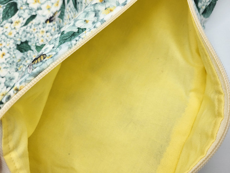 Close-up of a yellow fabric with floral patterned fabric partially visible