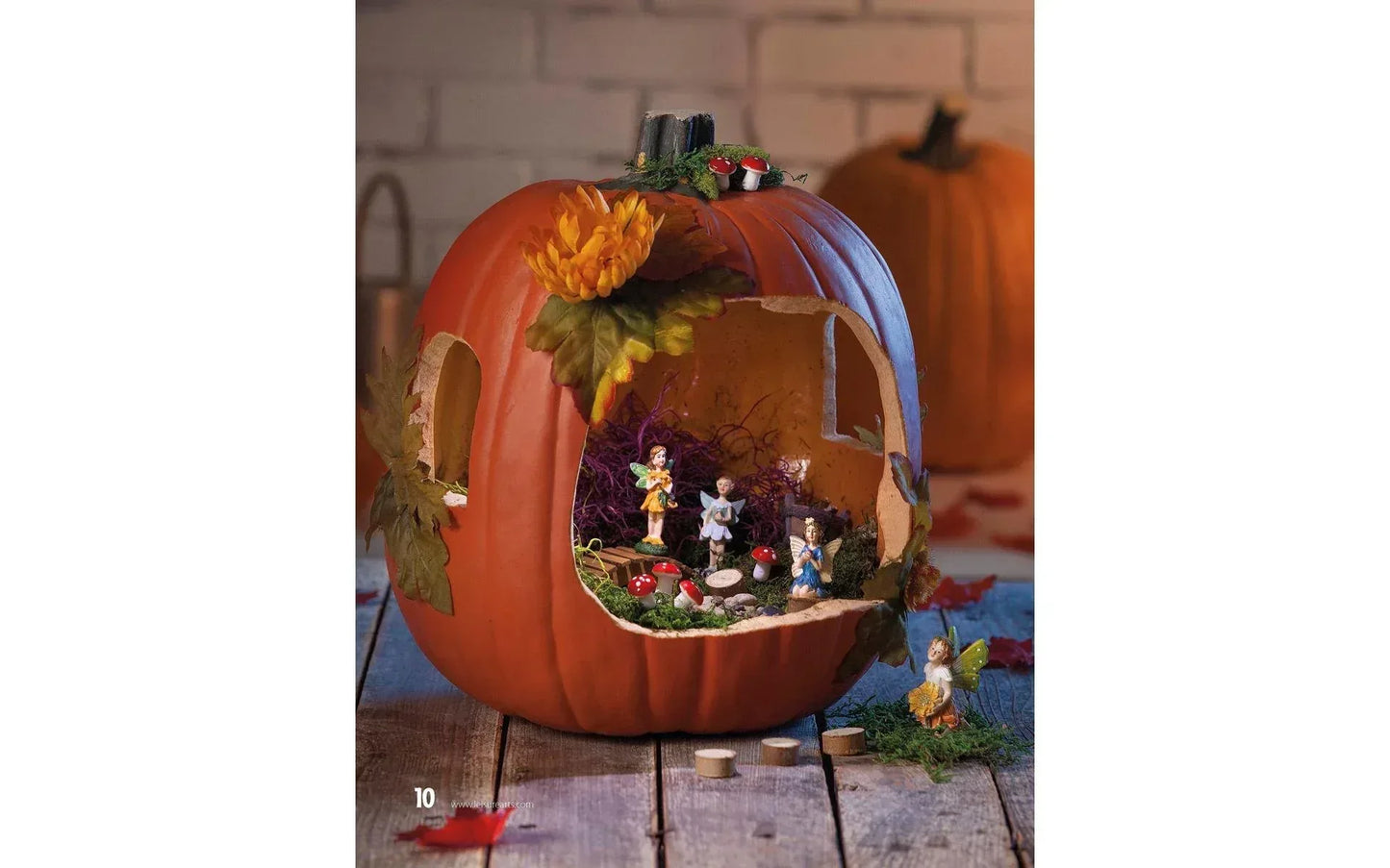 Decorative pumpkin with miniature figures and autumn elements on a wooden surface.
