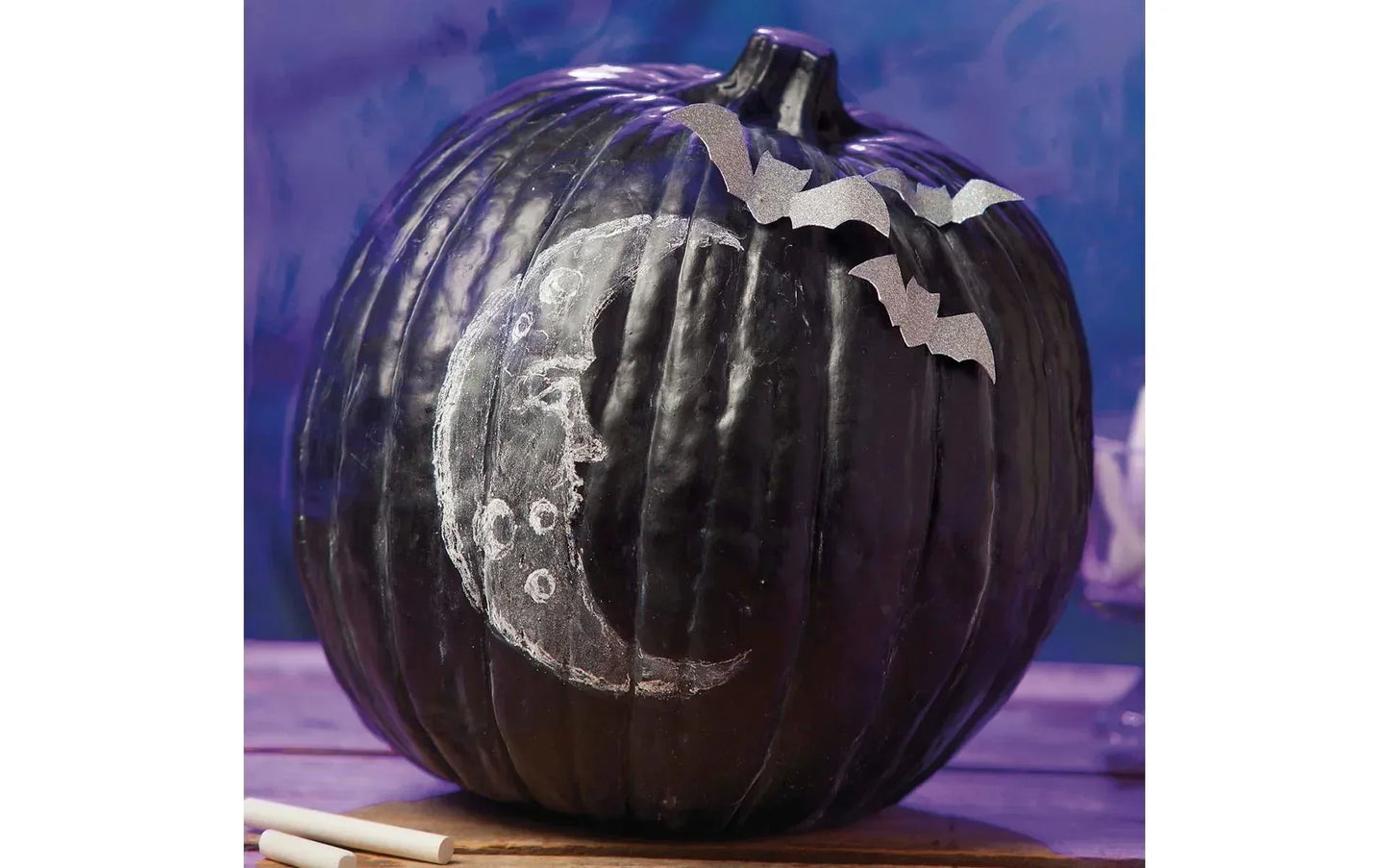 Decorative pumpkin with a moon and star design on a blue background