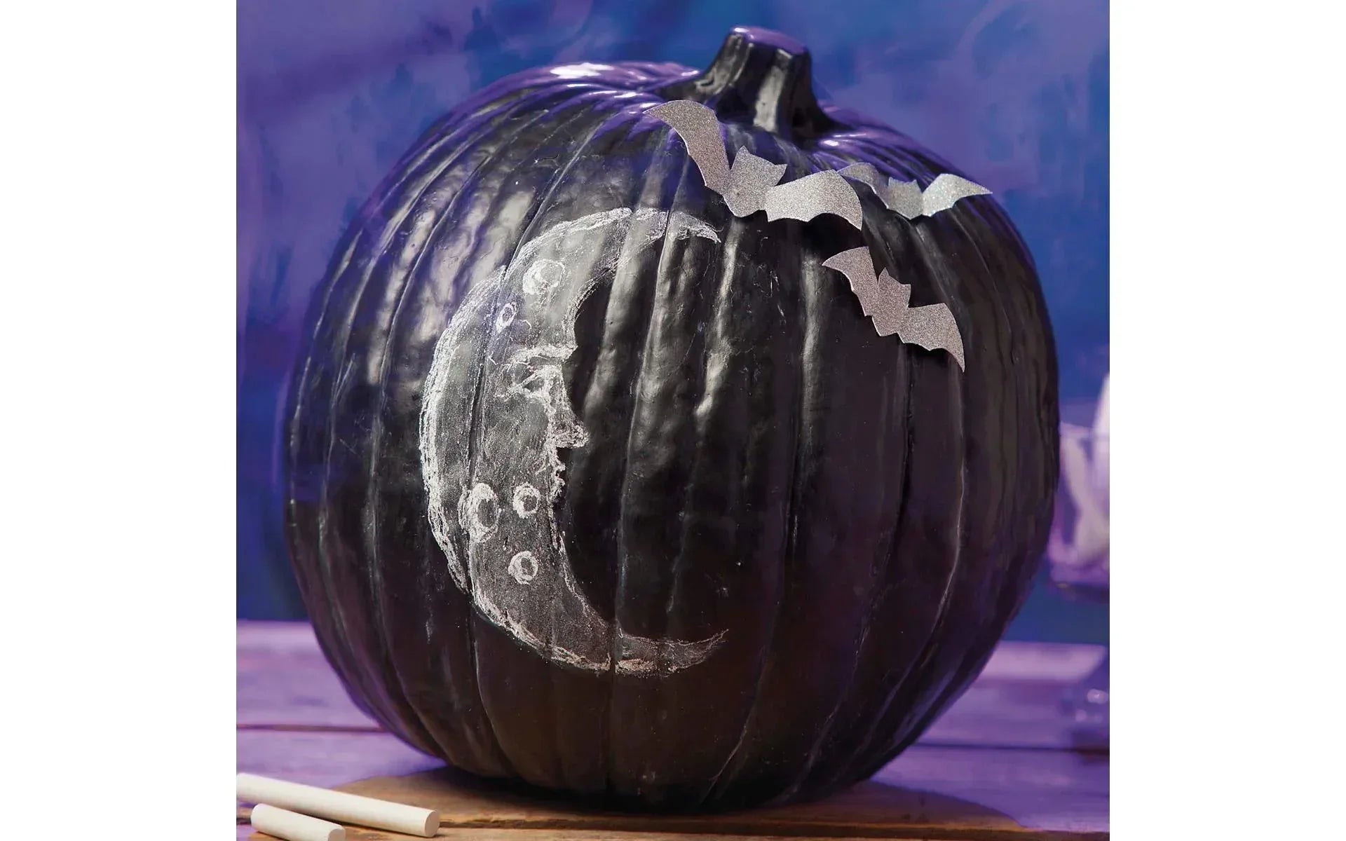 Decorative pumpkin with a moon and star design on a blue background