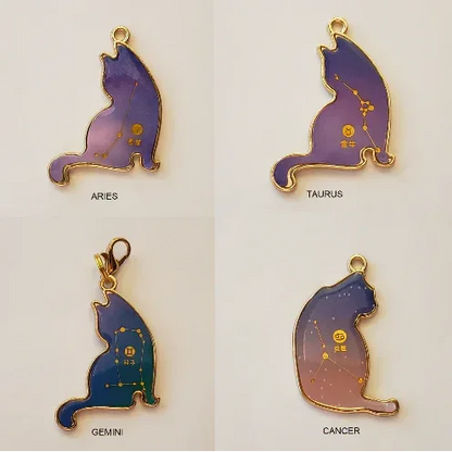 Four cat-shaped zodiac pendants labeled Aries, Taurus, Gemini, and Cancer on a light beige background.