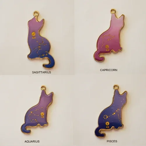 Four cat-shaped zodiac pendants on a light background