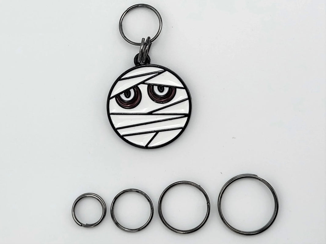Mummy stitch markers with ring attachments — flat lay sampler of ring sizes
